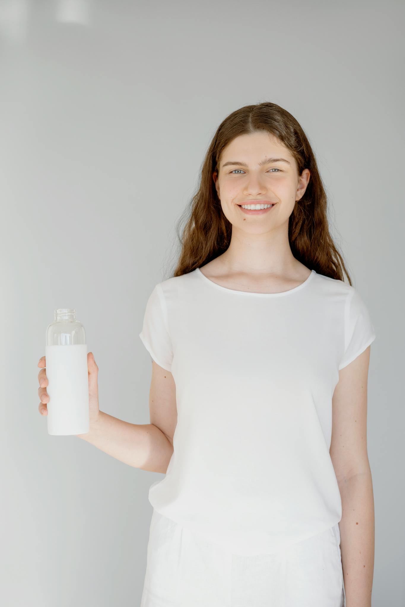 Persona hidratándose con agua, hábitos saludables de bienestar, mejorar energía diaria