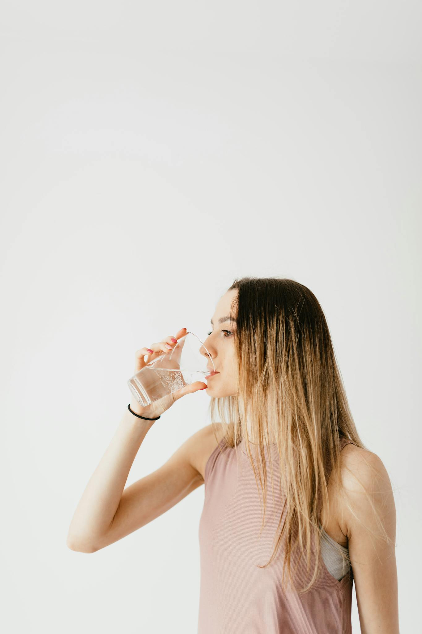 Persona hidratándose con agua, hábitos saludables de bienestar, mejorar energía diaria