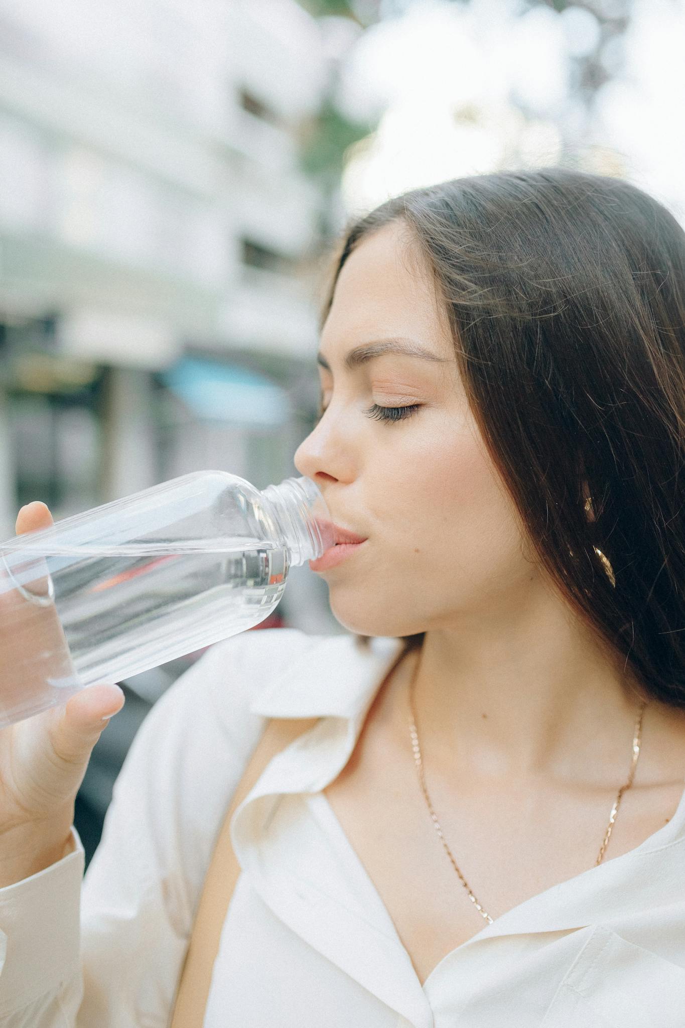 Persona hidratándose con agua, hábitos saludables de bienestar, mejorar energía diaria